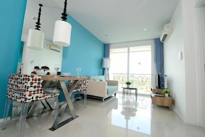 Una sala de estar moderna con comedor, sofá y balcón con vistas.