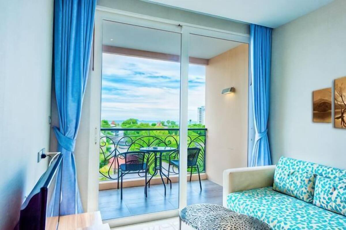 Een balkon met uitzicht, een bank en een tafel.