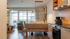 Une cuisine moderne dotée d’un four encastré et d’un coin repas avec un banc.