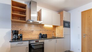 Une cuisine moderne avec des éléments en bois, des appareils électroménagers intégrés et un plancher en bois.