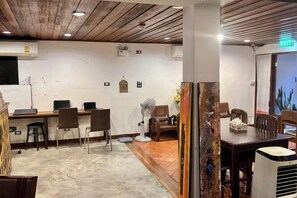 A hotel lobby with a reception desk, seating area, and a staircase leading to an upper floor. - Baan Heart Thai (Chiang Mai)