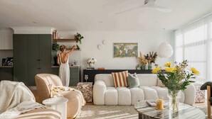 Un salon moderne avec un canapé, une table basse et des plantes décoratives.
