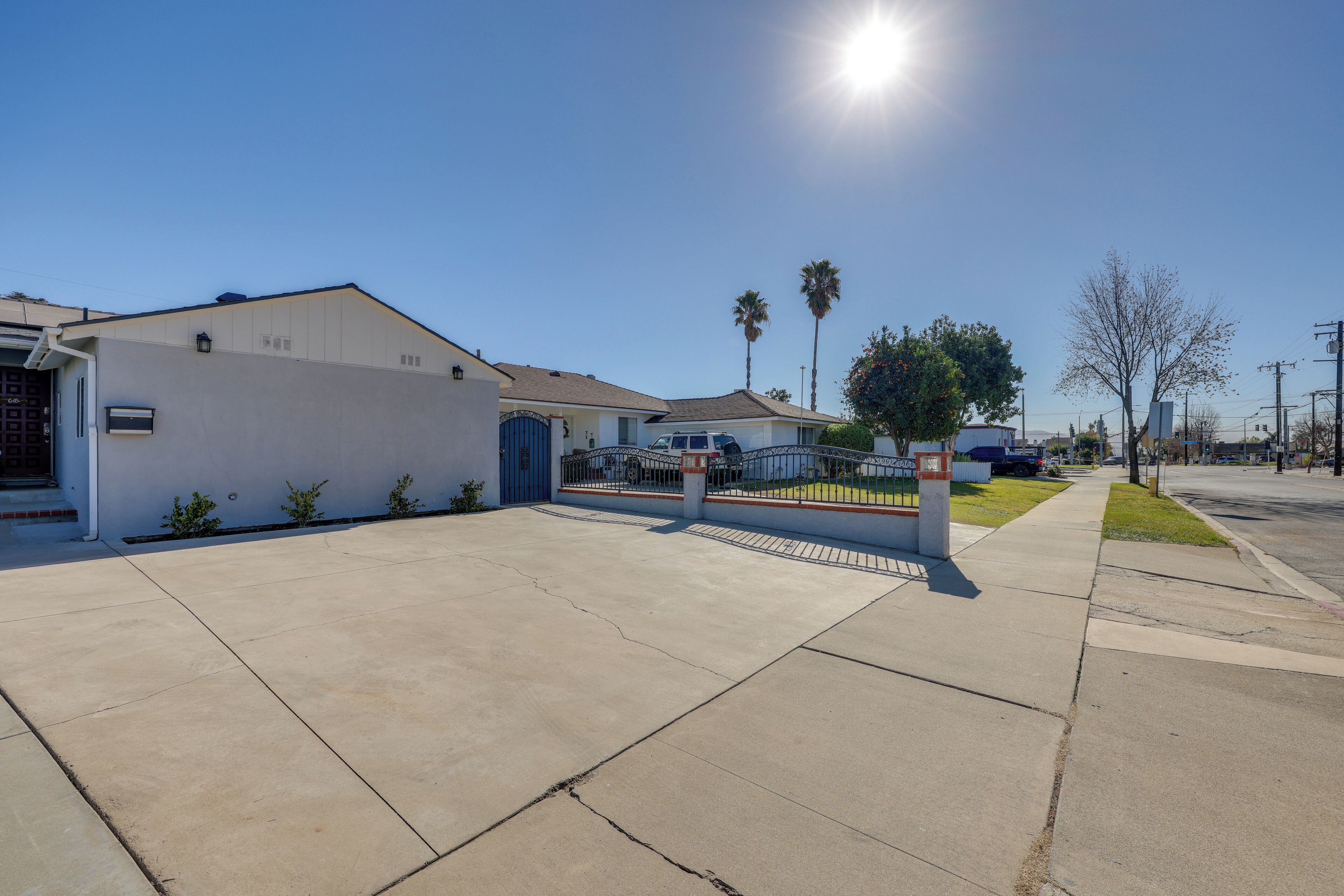 A residential street with houses, a clear sky, and a sunny day.