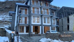 A multi-story hotel with a stone facade, large windows, and a sign reading "THE BULLWARS". - The Bulevar-Whispering Willow (Lahul)