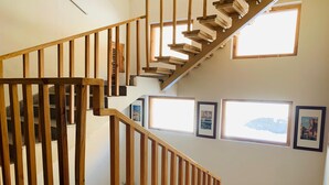 A wooden staircase with a view of the city through a window. - The Bulevar-Whispering Willow (Lahul)