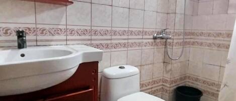 A bathroom with a sink, toilet, and shower.