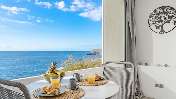 A balcony with a table set for breakfast, overlooking the ocean. - Ocean Loka by Interhome (Callao Salvaje)