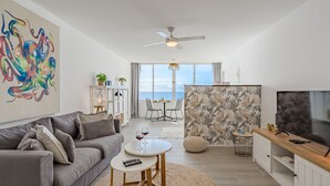 A modern living room with a grey sofa, a round coffee table, and a TV stand. - Ocean Loka by Interhome (Callao Salvaje)