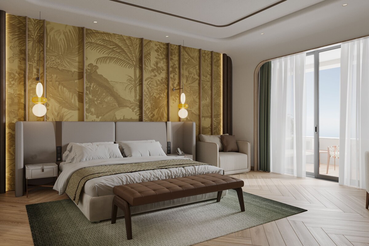 A modern bedroom with a large bed, a bench, a nightstand, and a view of the outdoors.