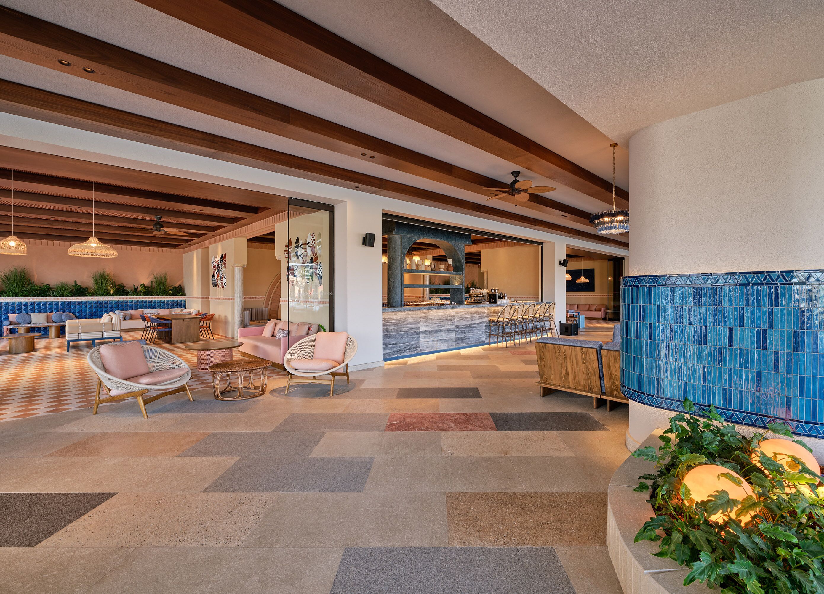 A spacious lobby with a bar area, seating arrangements, and a view of the pool.