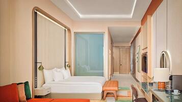 A hotel room with a bed, a desk, a sofa, a coffee table, and a ceiling fan.