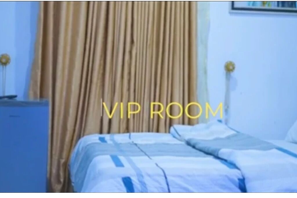 A room with a bed, curtains, and a blue cabinet.