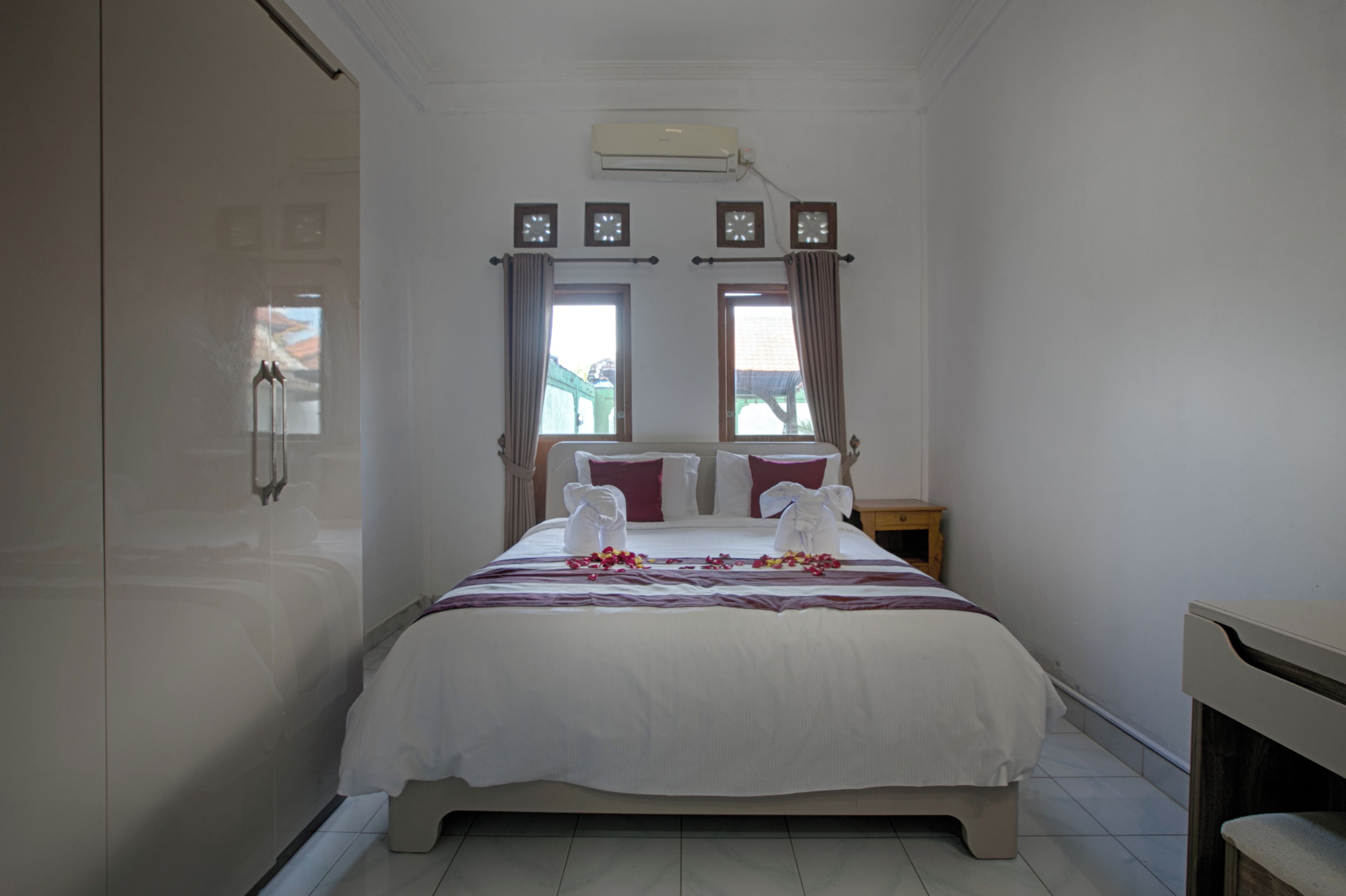 Une chambre d’hôtel avec un lit, une table de chevet et une fenêtre avec des rideaux.