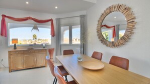 Un comedor con una mesa de madera, sillas y un espejo grande.