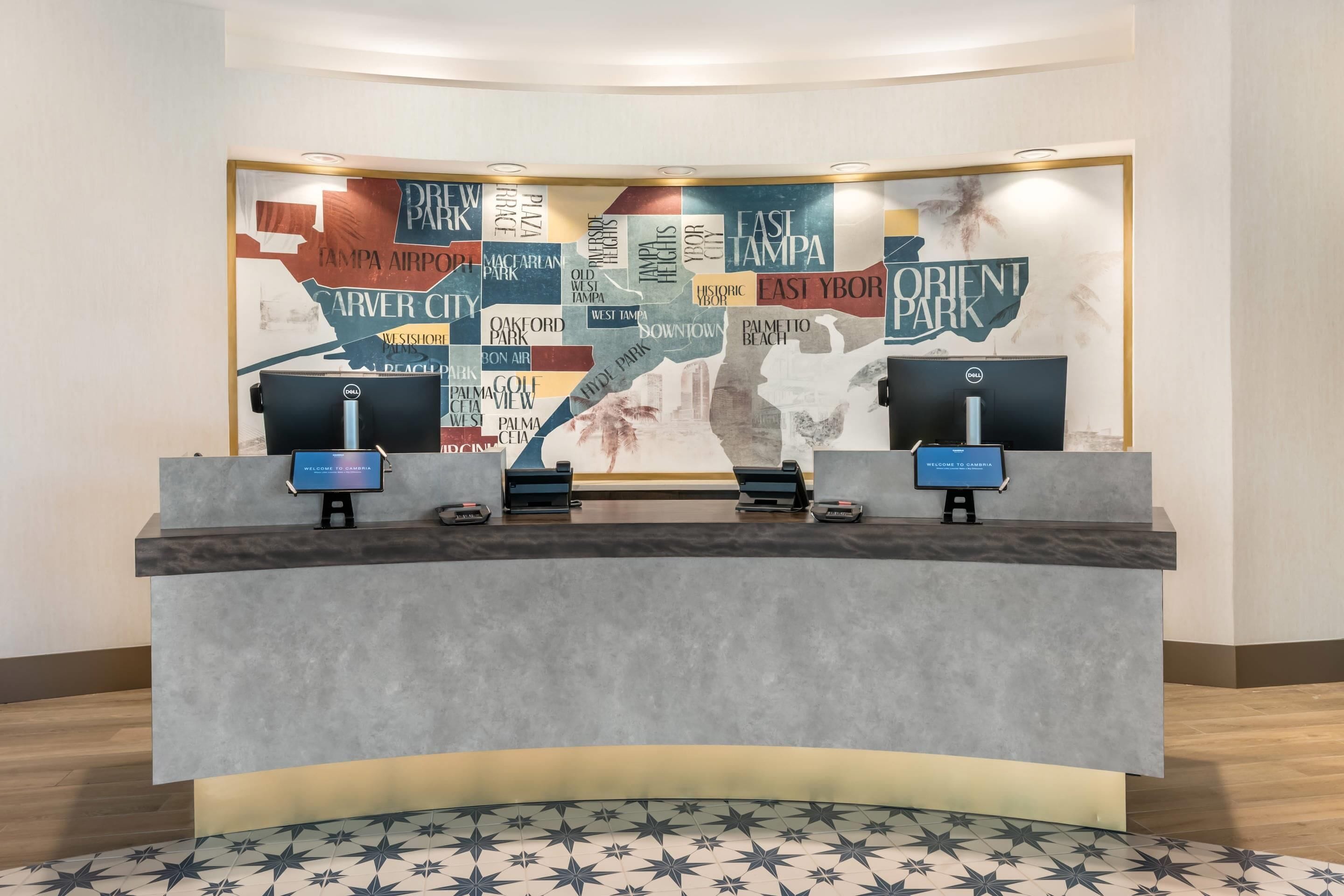 Een hotel receptiebalie met een grote kaart van Tampa, Florida, en een Dell computermonitor.