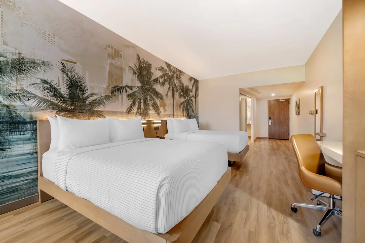 Une chambre d’hôtel avec un grand lit, un bureau et une chaise.