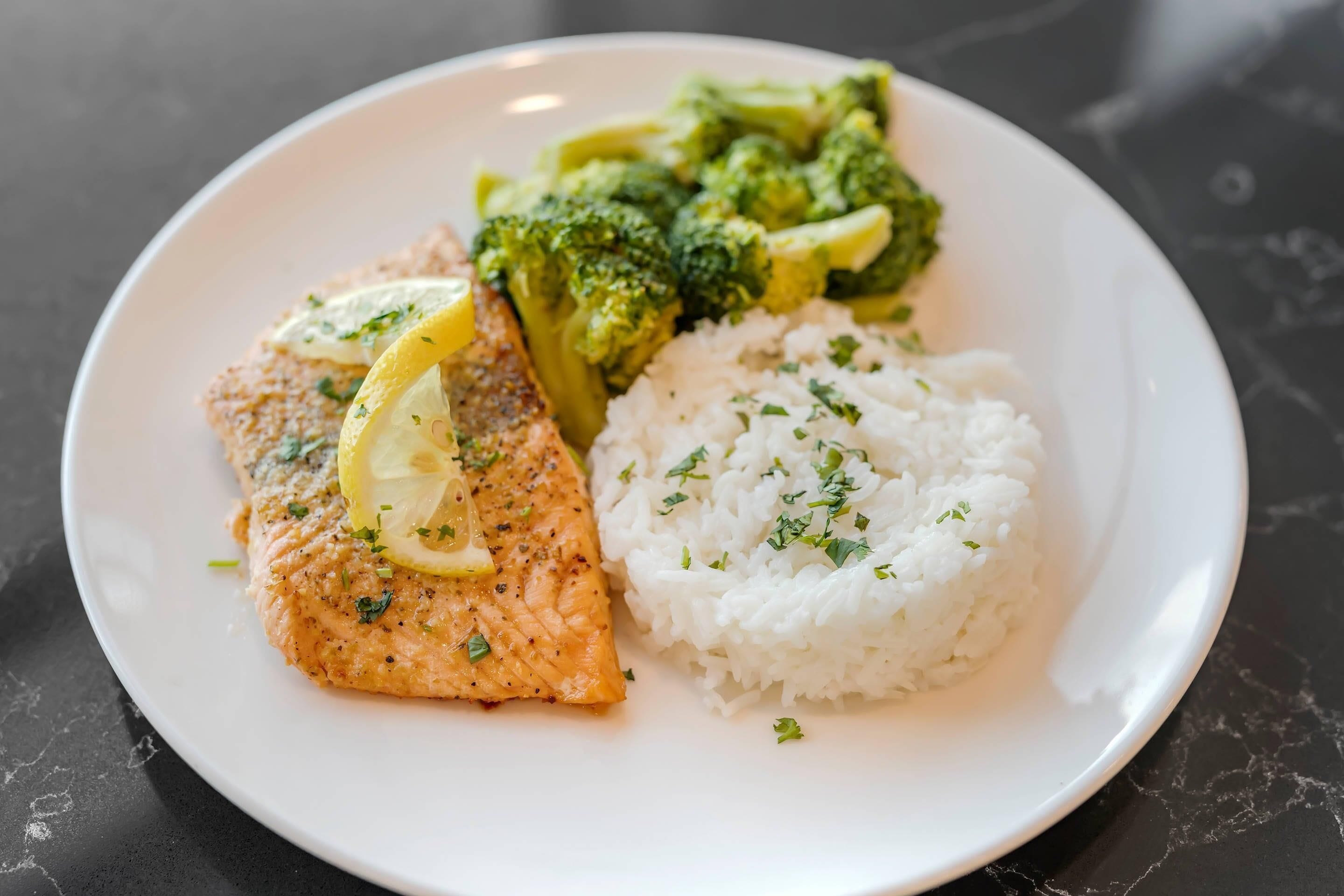 Un plato de salmón, brócoli y arroz blanco.