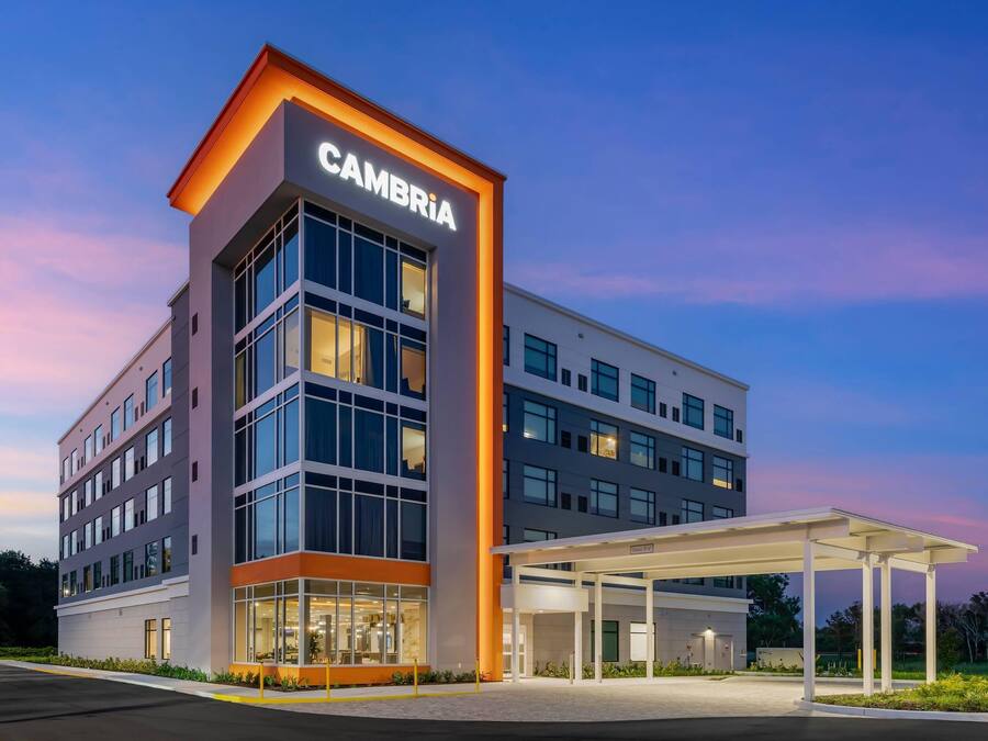 A modern building with a prominent 'CAMBRIA' sign, large windows, and a covered entrance area.