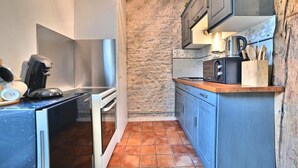 A compact kitchen with a stone wall, a coffee machine, and a knife block. - ღ Jungle Rochelaise • Hypercentre, 4K TV, Fibre (La Rochelle)