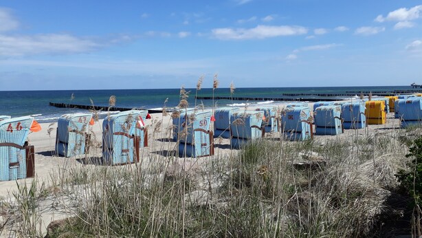Beach chairs lined up on the sand with a pier in the background. - Holiday Apartment 'Seestern' with Shared Garden and Wi-Fi (Kühlungsborn)
