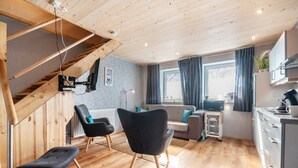 Un intérieur moderne avec un escalier en bois, un coin repas et une cuisine.