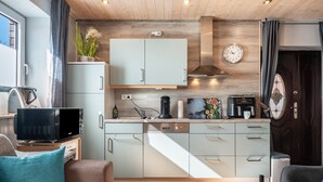Une cuisine moderne équipée d’un four à micro-ondes, d’une machine à café et d’une horloge murale.