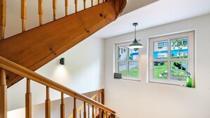 A wooden staircase with a view of the outside through a window. - Apartment 'Klassenzimmer' with Mountain View, Shared Terrace and Wi-Fi (Enzklösterle)