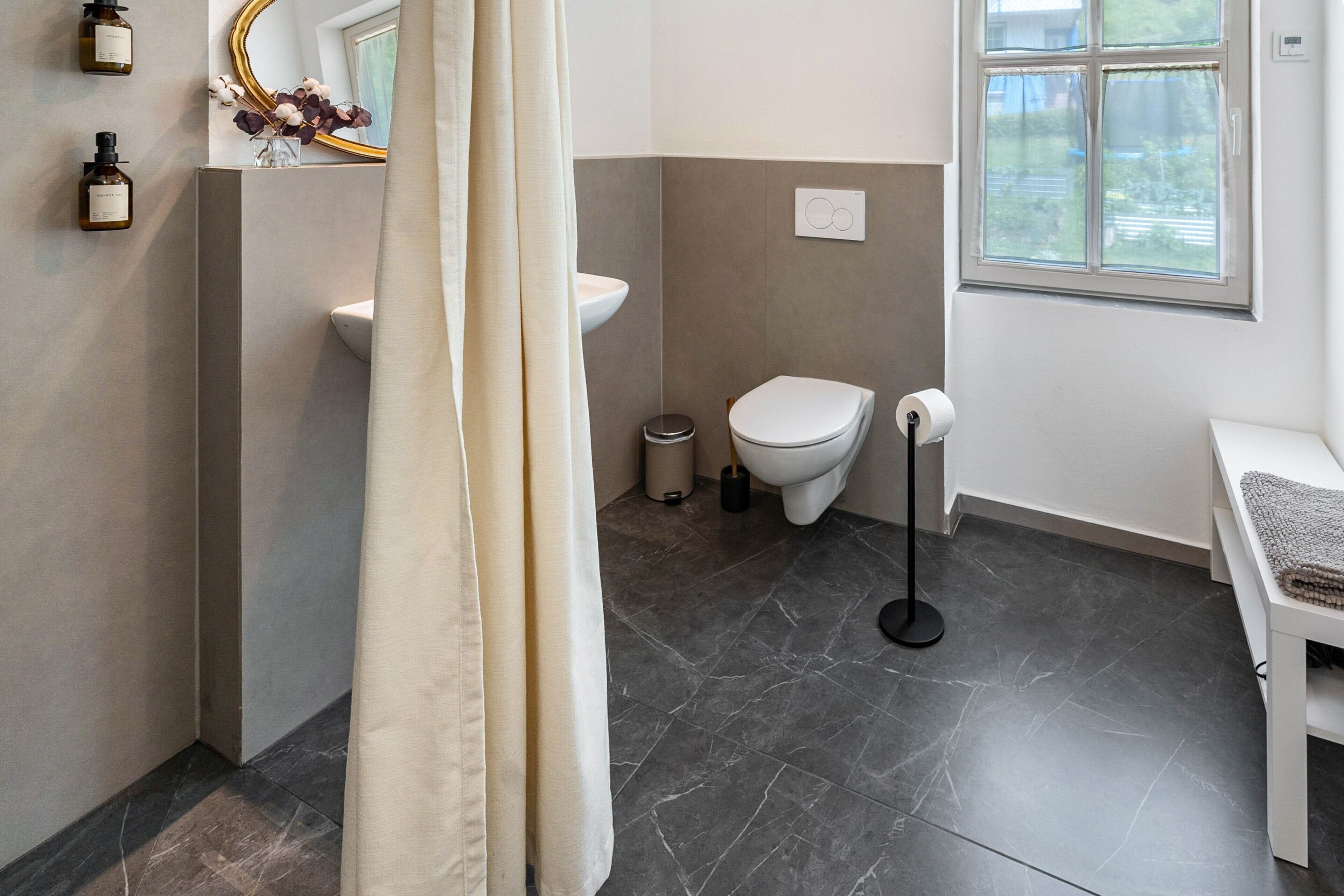 A bathroom with a toilet, sink, and shower curtain.