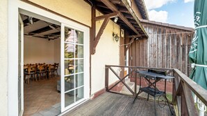 Un patio exterior con terraza de madera, una parrilla y un área de estar cubierta.