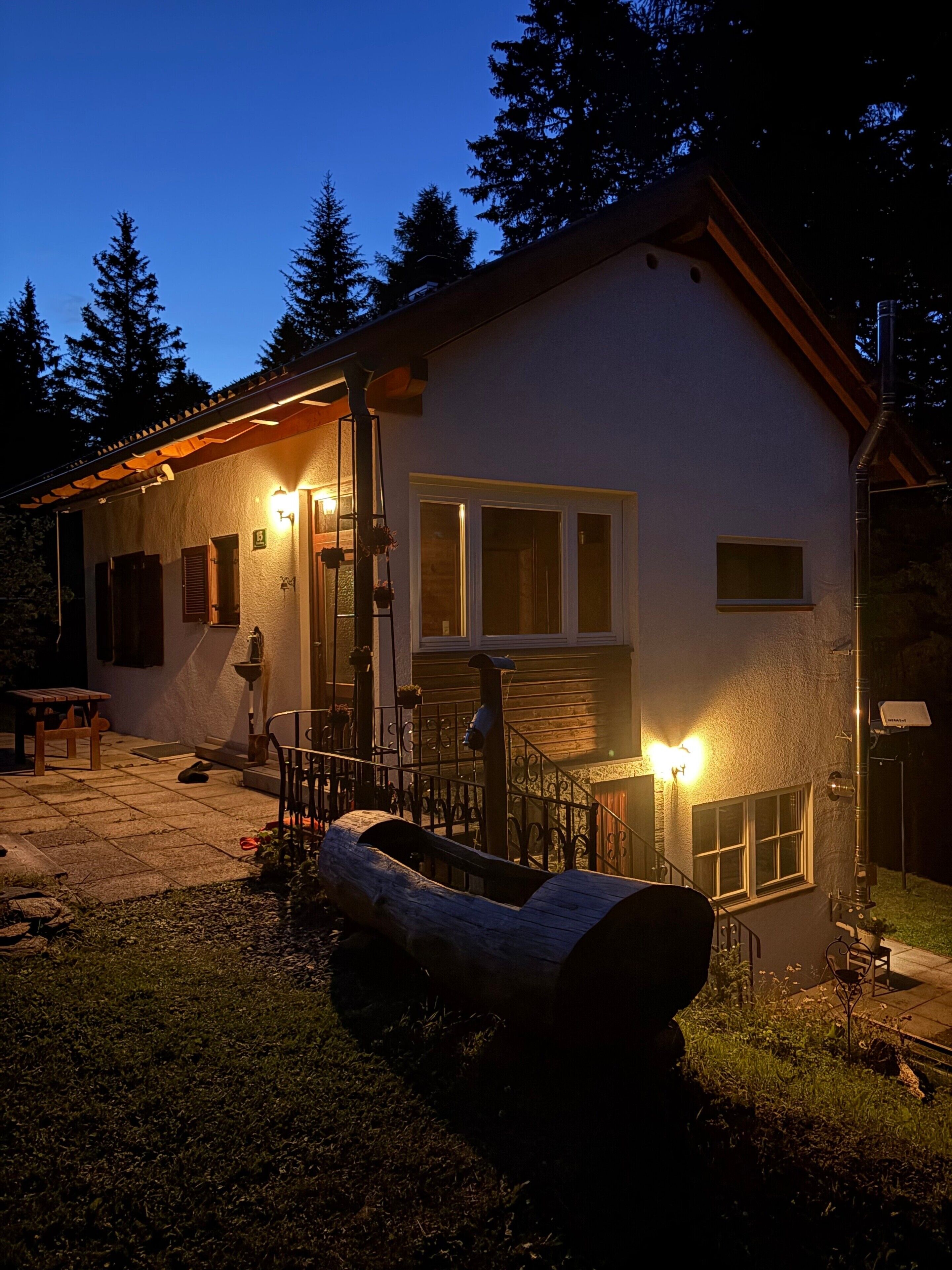 A house with a porch, a wooden bench, and a metal railing.