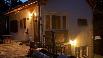 A house with a porch, a wooden bench, and a metal railing.