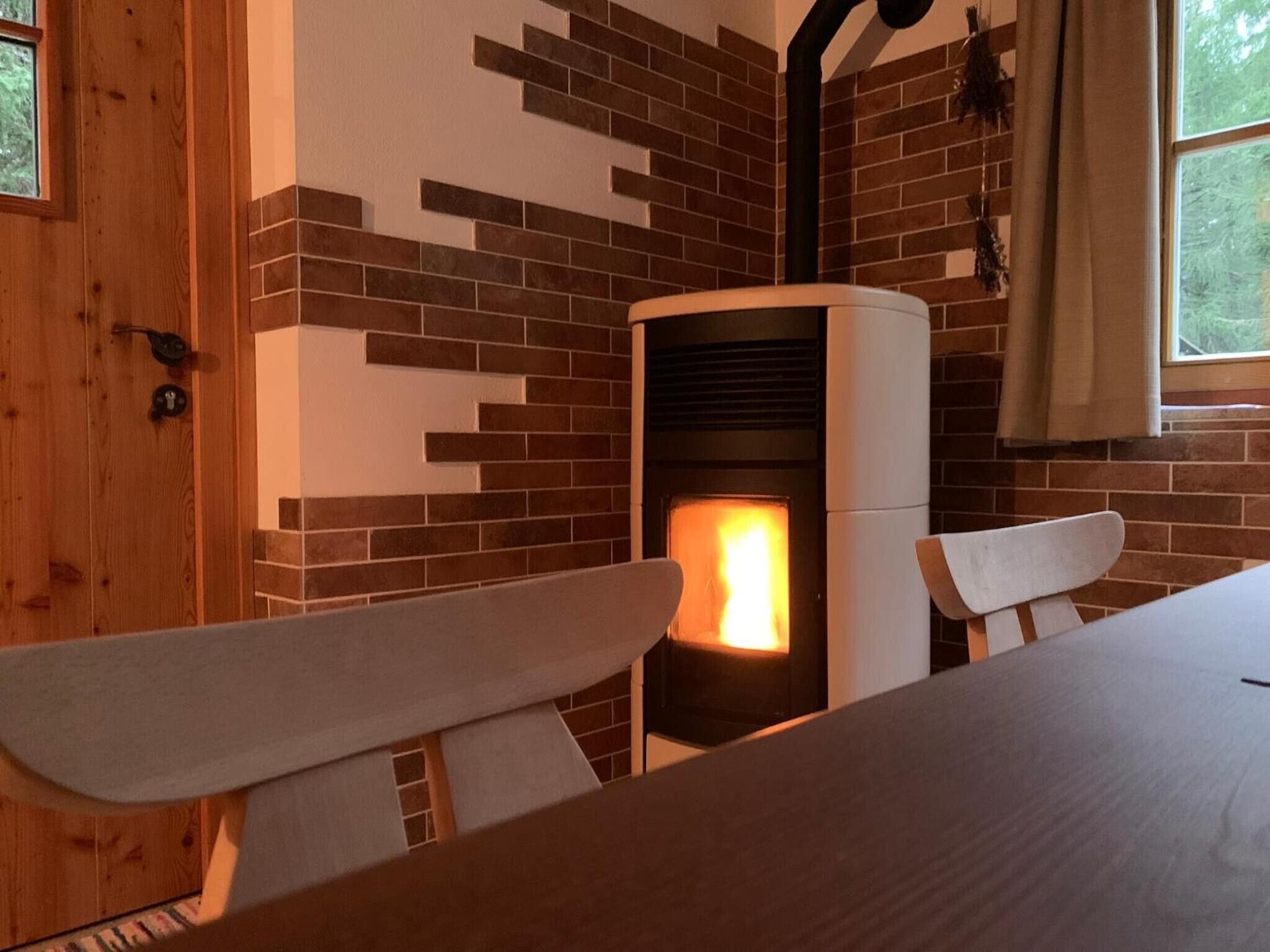 Une pièce avec une cheminée, des murs en bois et une fenêtre.