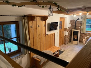 A cozy room with a wooden bench, a TV, a fireplace, and a window with curtains.
