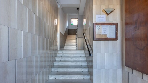 Ein modernes Interieur mit einer Marmortreppe, Glastrennlärm und einer Holzvertäfelung.