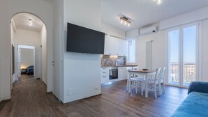 Ein modernes Apartment mit Küche, Essbereich und einem Balkon.