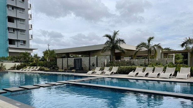 Une piscine avec des chaises longues et des palmiers.