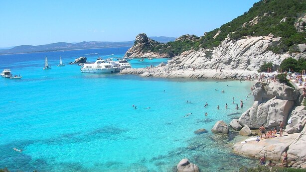 A coastal area with clear turquoise waters, rocky terrain, and boats. - Sea view terrace close to the beach of Lido di San Giovanni in Alghero (Alghero)