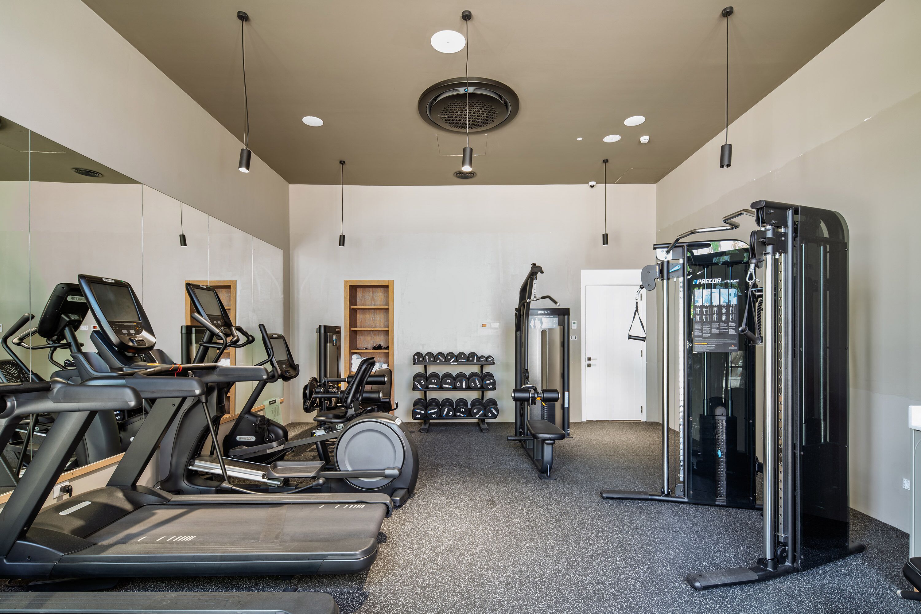 A gym with treadmills, dumbbells, and weight machines.