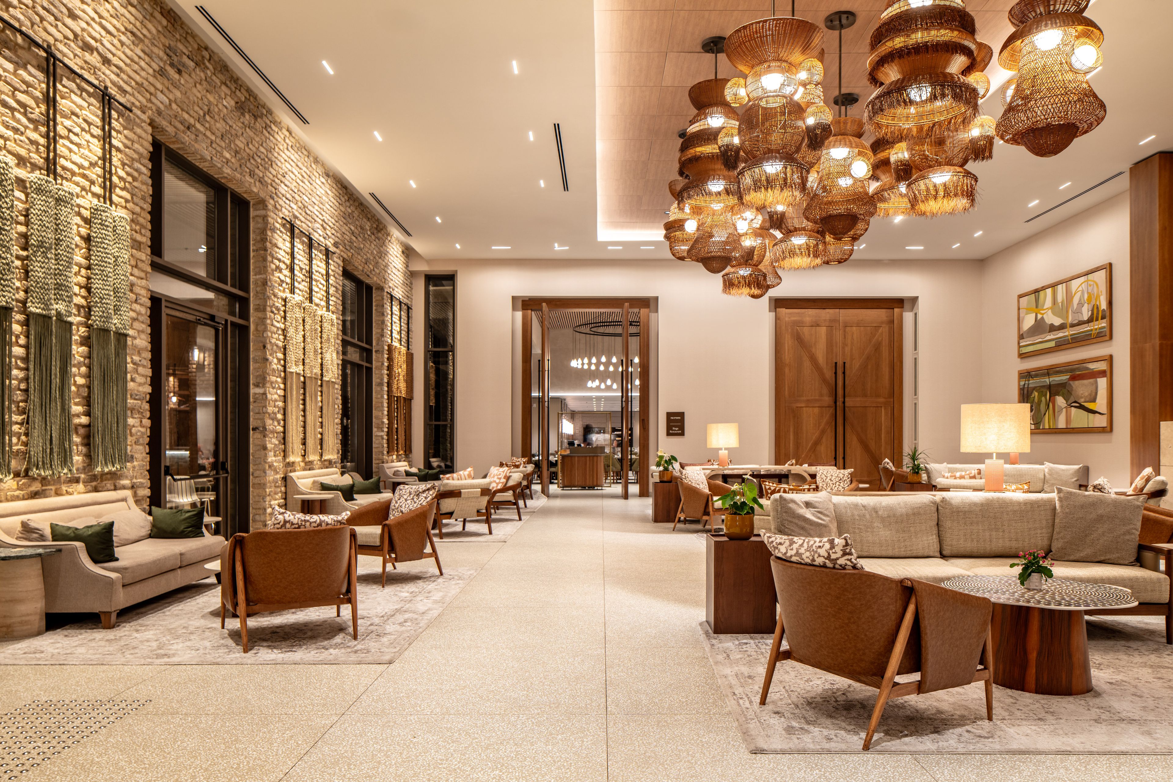 Een hotel lobby met een bakstenen muur, een zithoek en een grote houten deur.