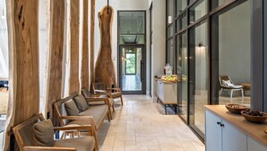 A modern interior with wooden beams, seating area, and a kitchen counter with bowls. - Ayala by Isrotel Collection (HaGalil HaElyon)