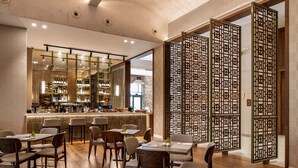 A modern bar area with a wooden floor, bar stools, and a well-lit counter. - Ayala by Isrotel Collection (HaGalil HaElyon)