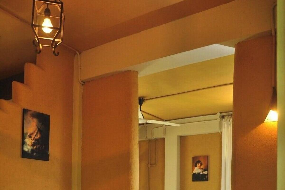 Une chambre d’hôtel avec un lit, une petite table sur laquelle se trouve un magazine et un tableau accroché au mur.