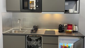 A compact kitchen with a built-in microwave, a dishwasher, and a refrigerator.