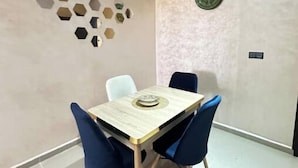 Un comedor con una mesa, sillas, un adorno de pared y un reloj.
