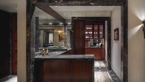 A modern bathroom with a marble countertop, wooden vanity, and a large mirror. - Palazzo Ottaviani Luxury Apartments (Florence)