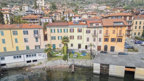 Un pueblo costero con edificios de colores, un pequeño muelle y una vista despejada del agua.