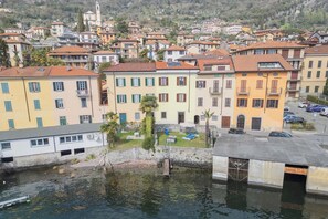 Une ville côtière aux bâtiments aux couleurs vives, avec un petit quai et une vue dégagée sur l’eau.