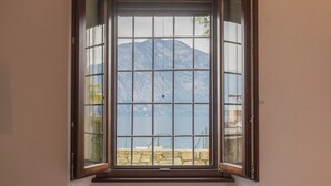Una ventana con vistas a un paisaje montañoso y un cuerpo de agua.