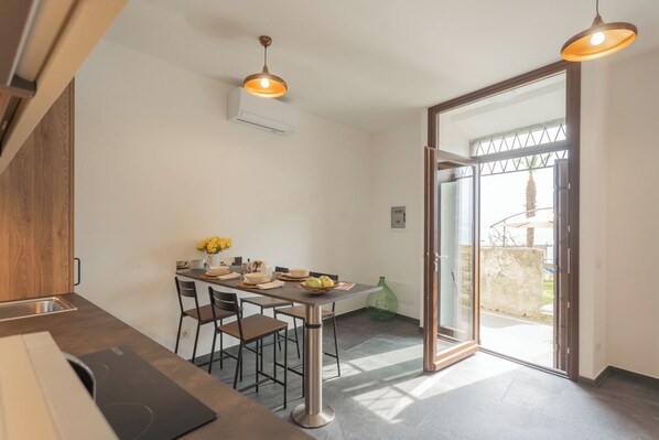 Una cocina moderna con una mesa de comedor, sillas y vistas al exterior a través de un ventanal.