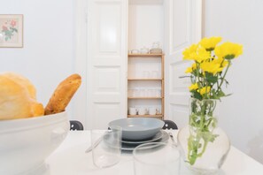A dining table with a bowl of bread, a vase with yellow flowers, and a set of plates and glasses. - Da Pia in Historycal Como City Centre by Rent all Como (Como)